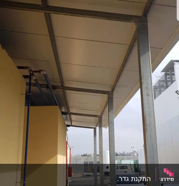 מסגרת מתכת תומכת בגג מעל שביל